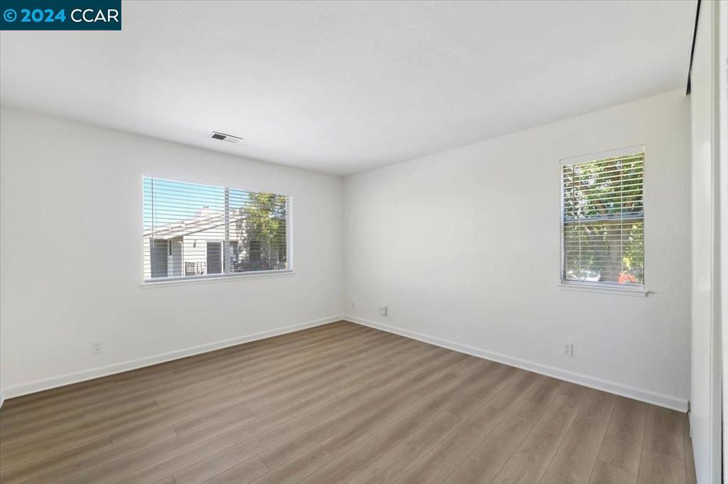 1050 Wesley Court Walnut Creek, CA 94597 - Photo 28 of 32 an empty room with wooden floor and windows