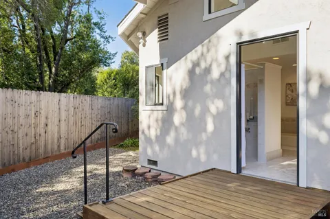 a view of a patio with table and chairs with wooden floor and fence