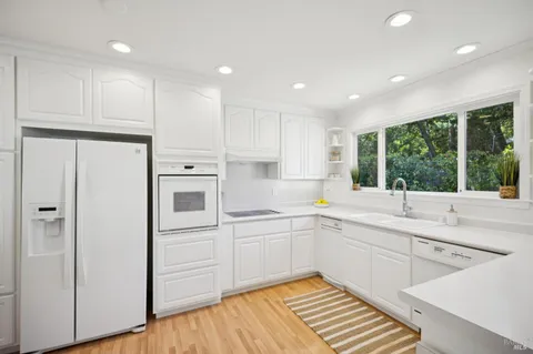 a kitchen with a sink cabinets and wooden floor