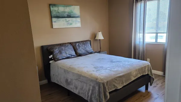 a bed sitting in a bedroom next to a window