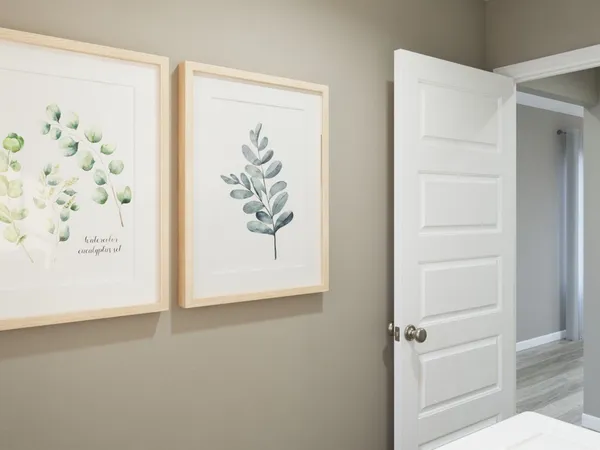 a bedroom with a bed and painting on the wall