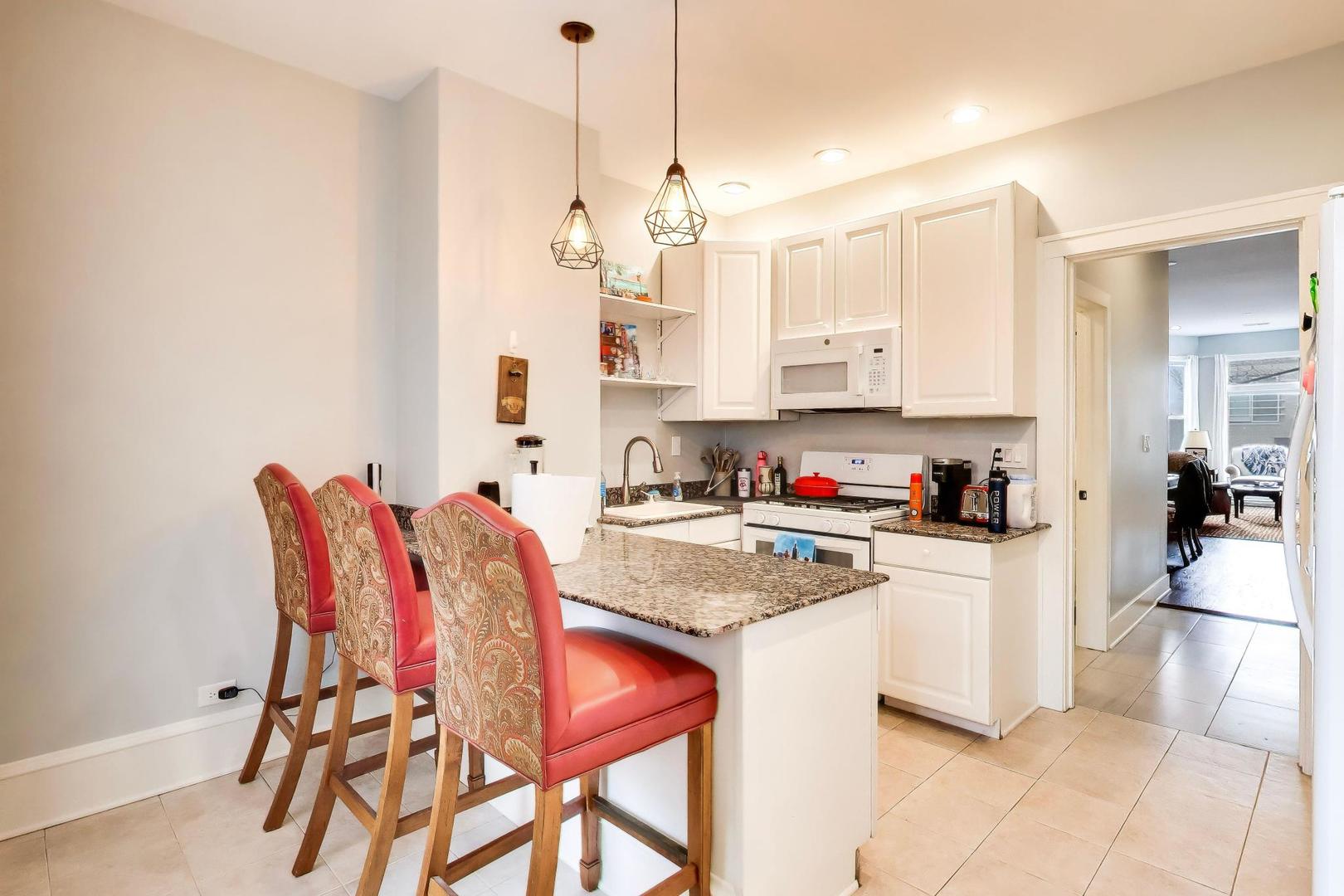 3519 North Seminary Avenue Chicago, IL 60657 - Photo 8 of 43 a kitchen with stainless steel appliances granite countertop a kitchen island a stove a refrigerator and white cabinets with wooden floor