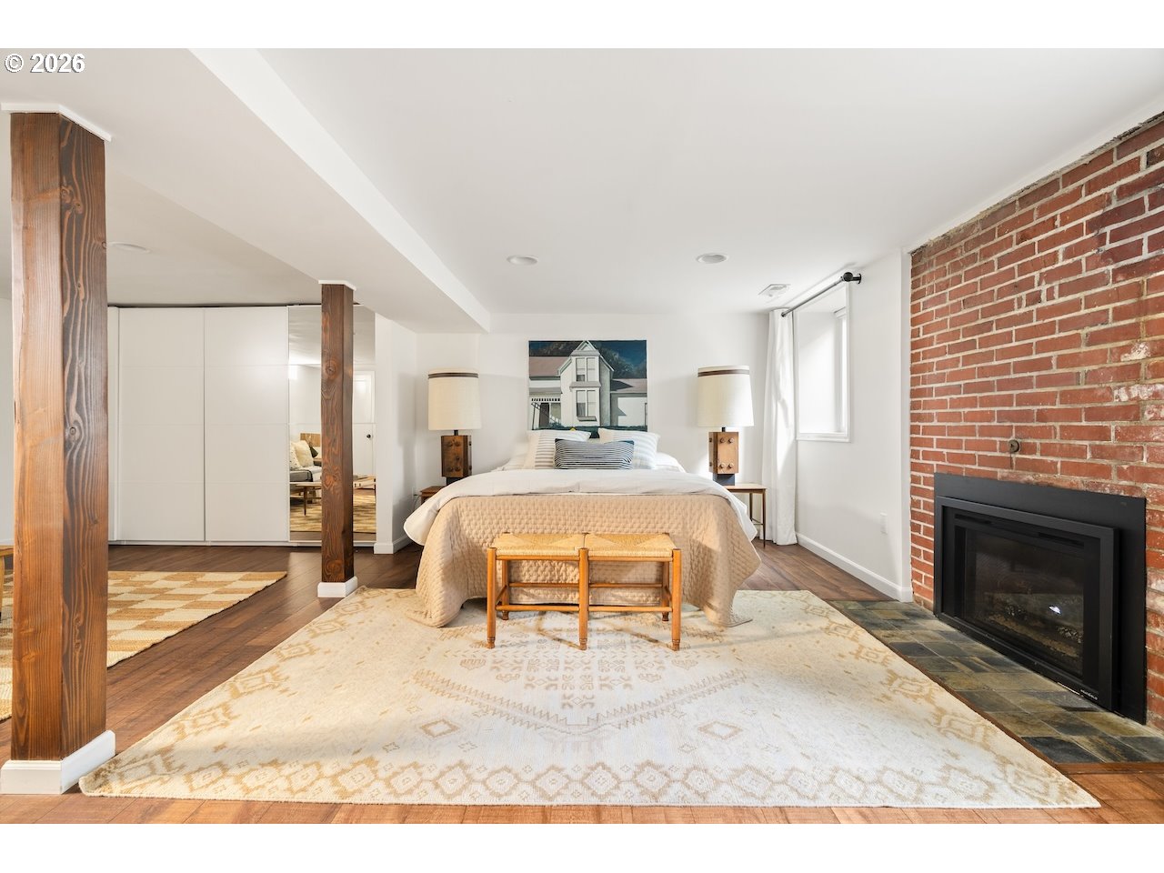 1606 North Alberta Street Portland, OR 97217 - Photo 27 of 46 a spacious bedroom with a bed a fireplace and a large window