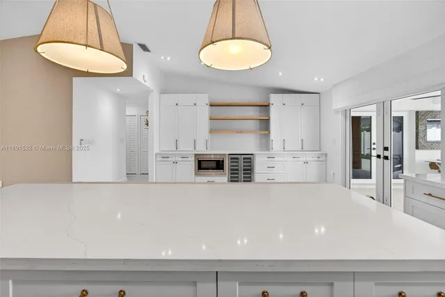 a living room with a table chairs and a chandelier