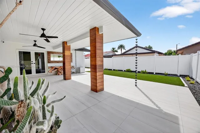 a front view of a house with a yard and potted plants