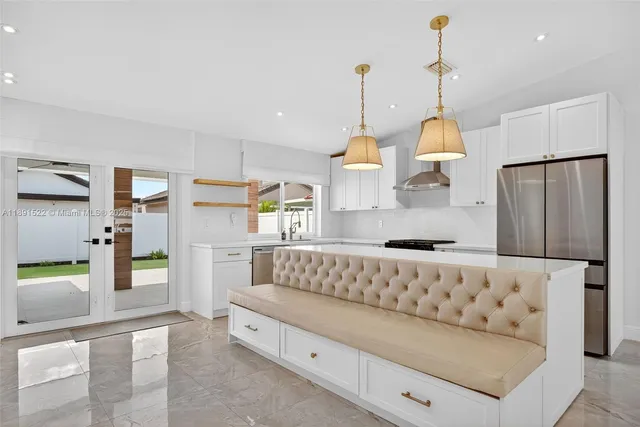 a kitchen with stainless steel appliances kitchen island granite countertop a refrigerator and a view of living room