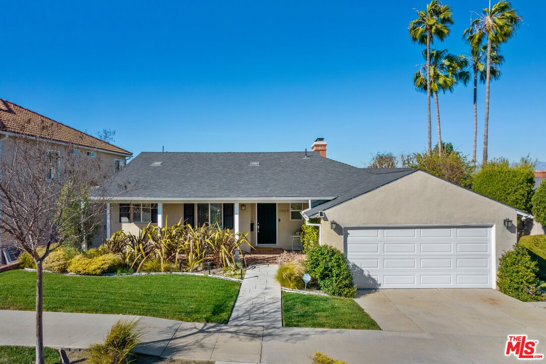 3869 Olympiad Drive View Park, CA 90043 - Photo 1 of 25 a front view of a house with garden