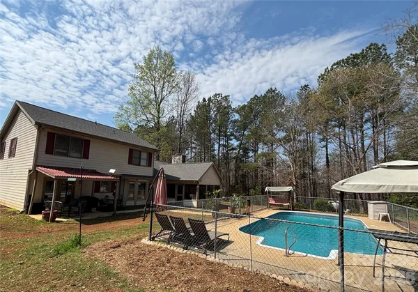 a view of a house with swimming pool and sitting area