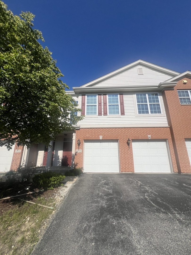 10205 Mulberry Lane, Unit J Bridgeview, IL 60455 - Photo 2 of 12 a front view of a house with a yard and garage