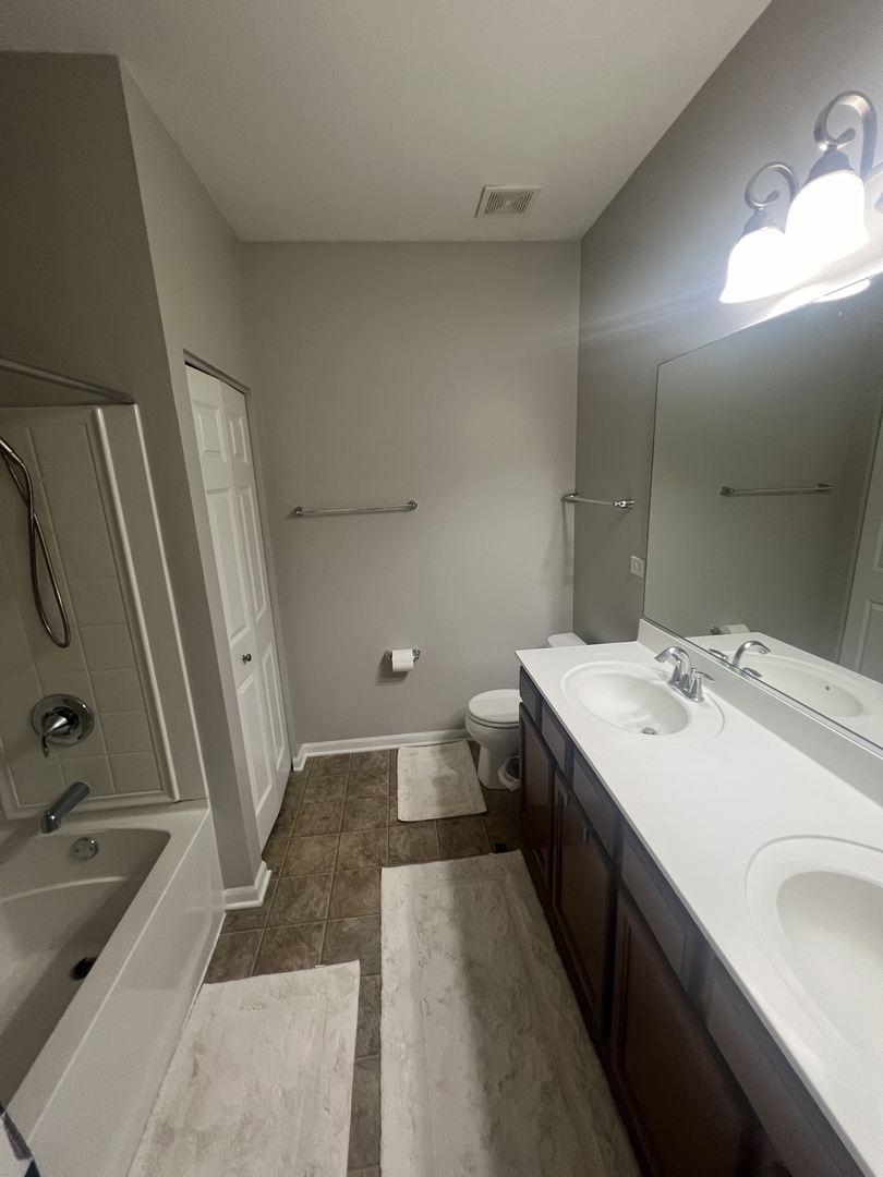 10205 Mulberry Lane, Unit J Bridgeview, IL 60455 - Photo 6 of 12 a bathroom with a sink a toilet a mirror and bathtub