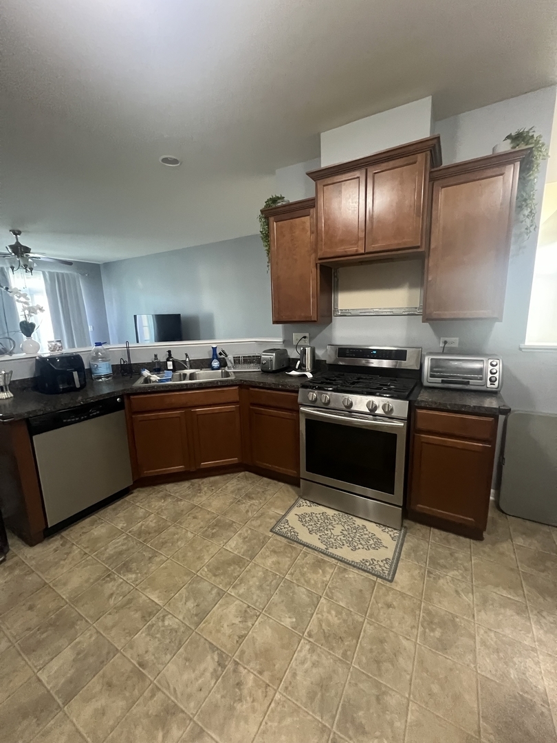 10205 Mulberry Lane, Unit J Bridgeview, IL 60455 - Photo 7 of 12 a kitchen with stainless steel appliances granite countertop a stove and a sink