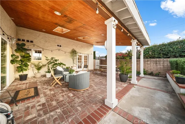 a view of a patio with table and chairs and wooden fence