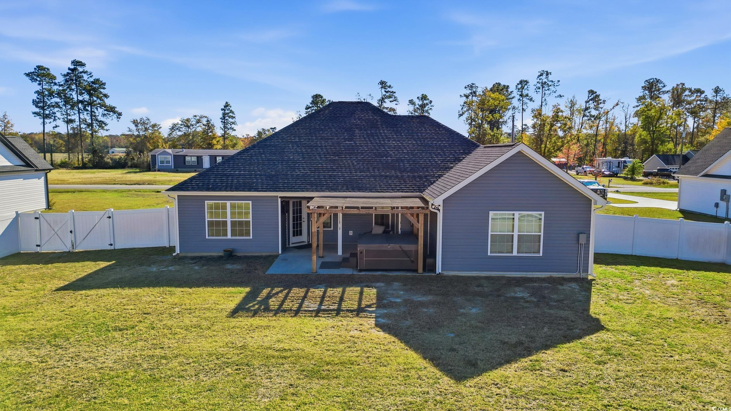 2295 Vaught Road Galivants Ferry, SC 29544 - Photo 20 of 26 Back of property featuring a gate, a hot tub, a fenced backyard, a patio, and roof with shingles