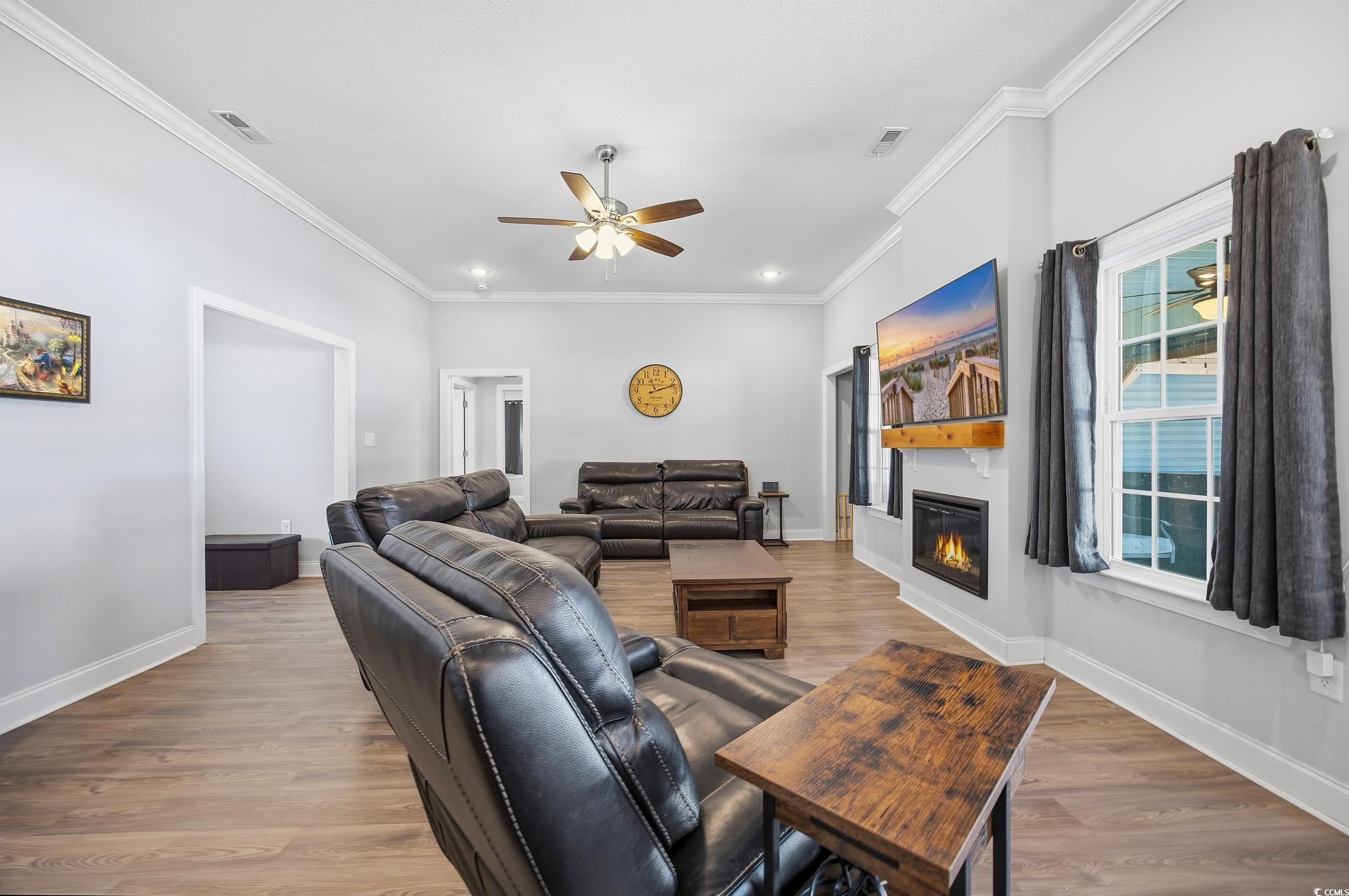 2295 Vaught Road Galivants Ferry, SC 29544 - Photo 6 of 26 Living room featuring light wood-type flooring, ornamental molding, a glass covered fireplace, ceiling fan, and recessed lighting