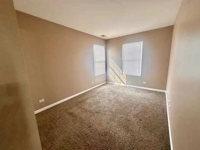 an empty room with an empty space and windows