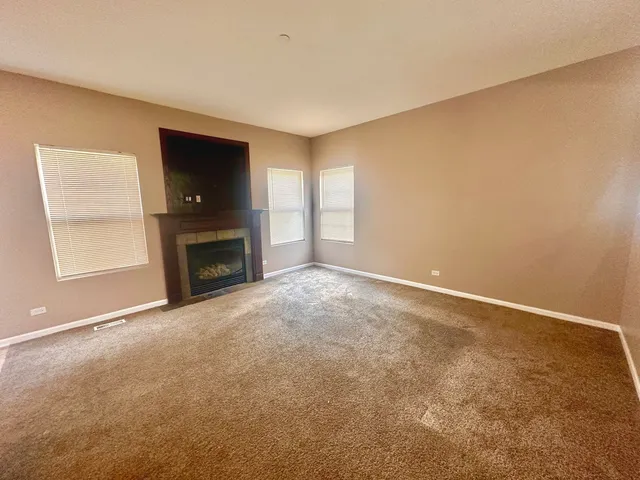 an empty room with fireplace and a window