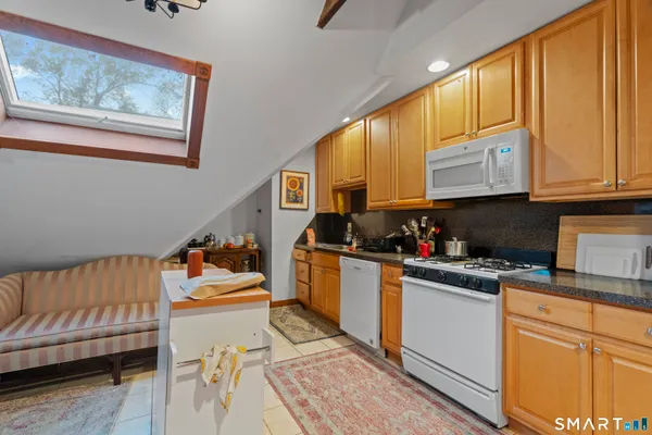 a kitchen with stainless steel appliances granite countertop a stove a sink dishwasher and cabinets with wooden floor