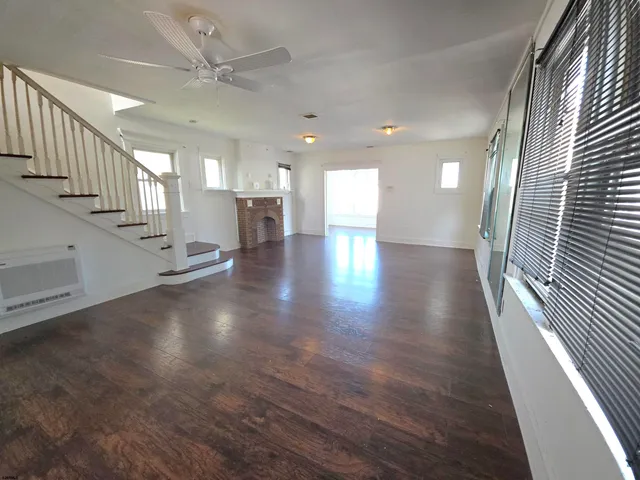 a view of a hallway with stairs and wooden floor