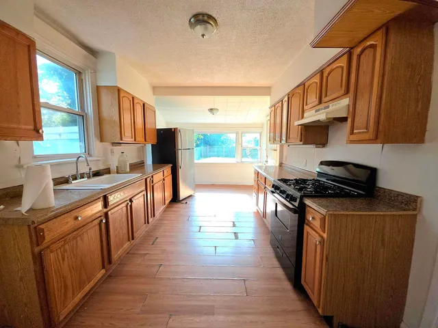 a kitchen with stainless steel appliances granite countertop a stove a sink dishwasher and a refrigerator