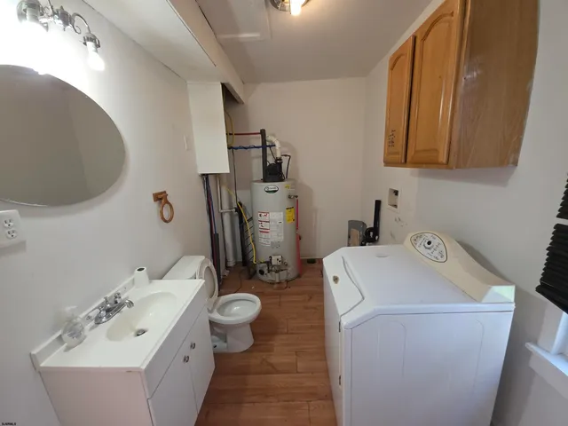 a bathroom with a sink and a washing machine with mirror