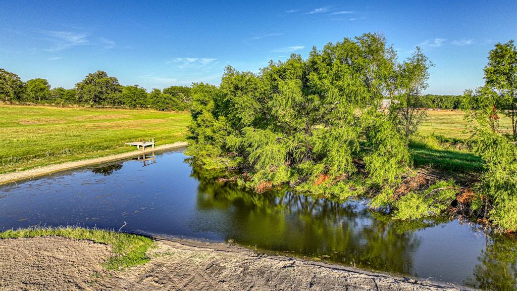 Lot 8 Carter Road Springtown, TX 76082 - Photo 7 of 8 a view of a lake with a house in the background