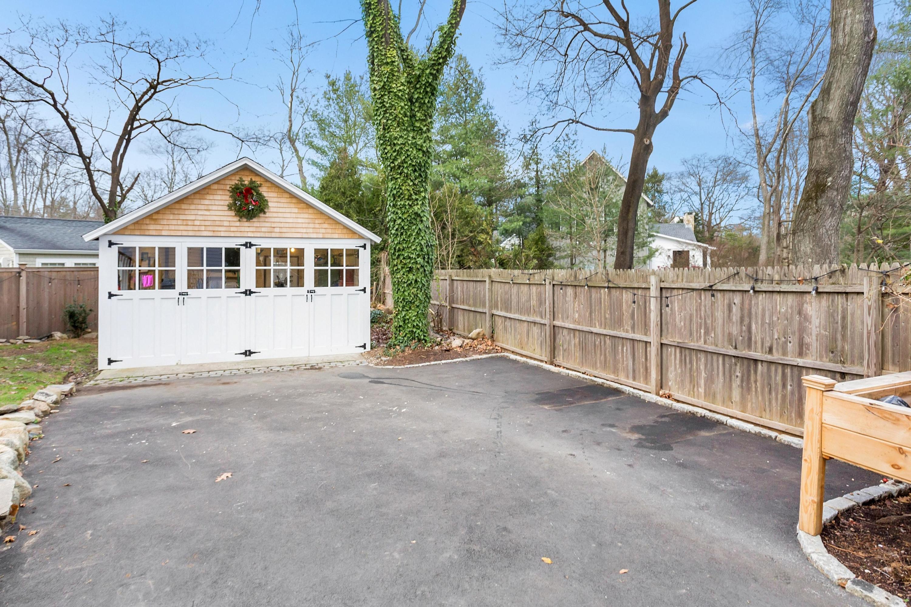 227 Middlesex Road Darien, CT 06820 - Photo 25 of 30 a view of a house with a wooden fence and a large tree