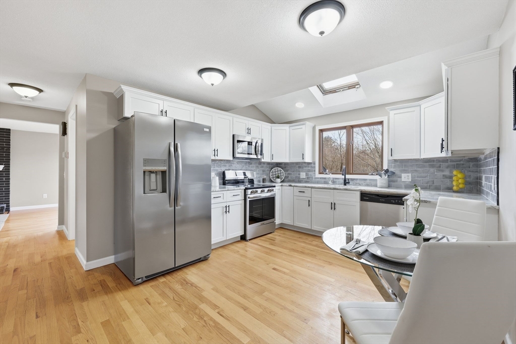 10 Woodcrest Road Springfield, MA 01129 - Photo 7 of 26 a kitchen with white cabinets and stainless steel appliances