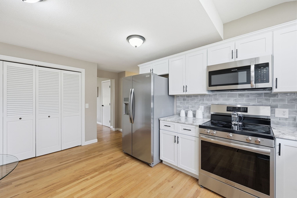 10 Woodcrest Road Springfield, MA 01129 - Photo 9 of 26 a kitchen with stainless steel appliances white cabinets a stove a microwave and a refrigerator