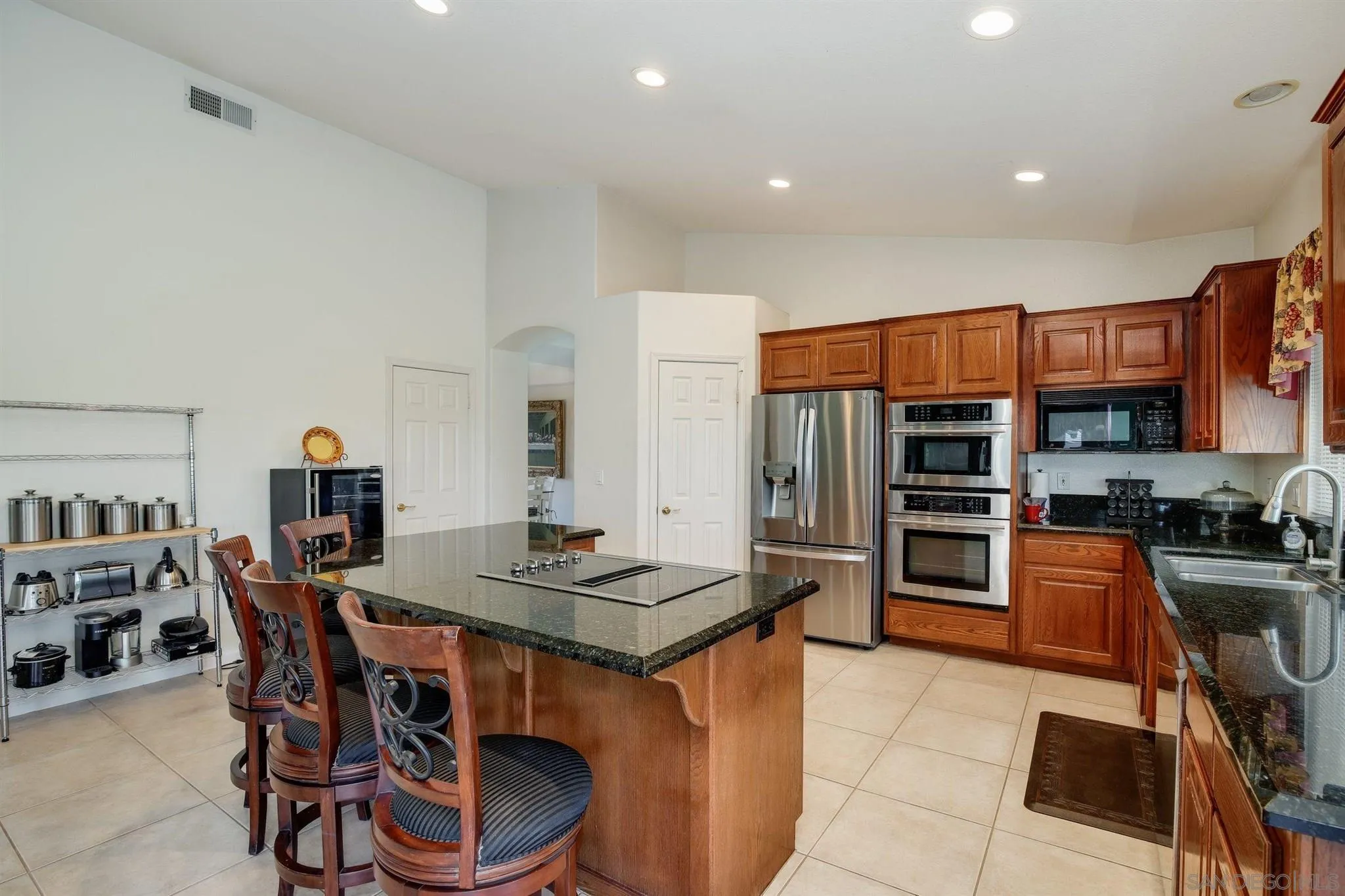 31210 Rivoli Road Valley Center, CA 92082 - Photo 12 of 62 a open dining room with stainless steel appliances a dining table and chairs