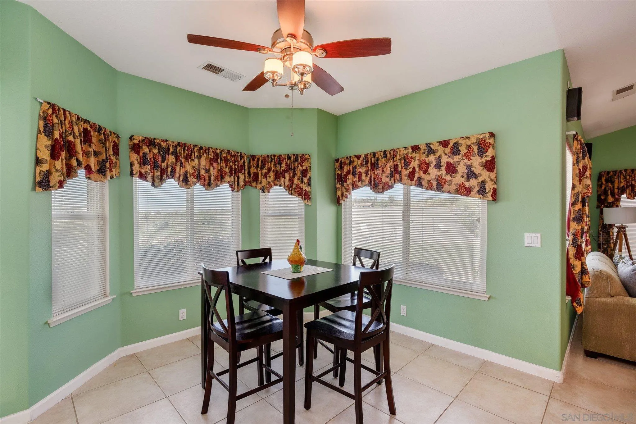 31210 Rivoli Road Valley Center, CA 92082 - Photo 15 of 62 a view of a dining room with furniture and a chandelier fan
