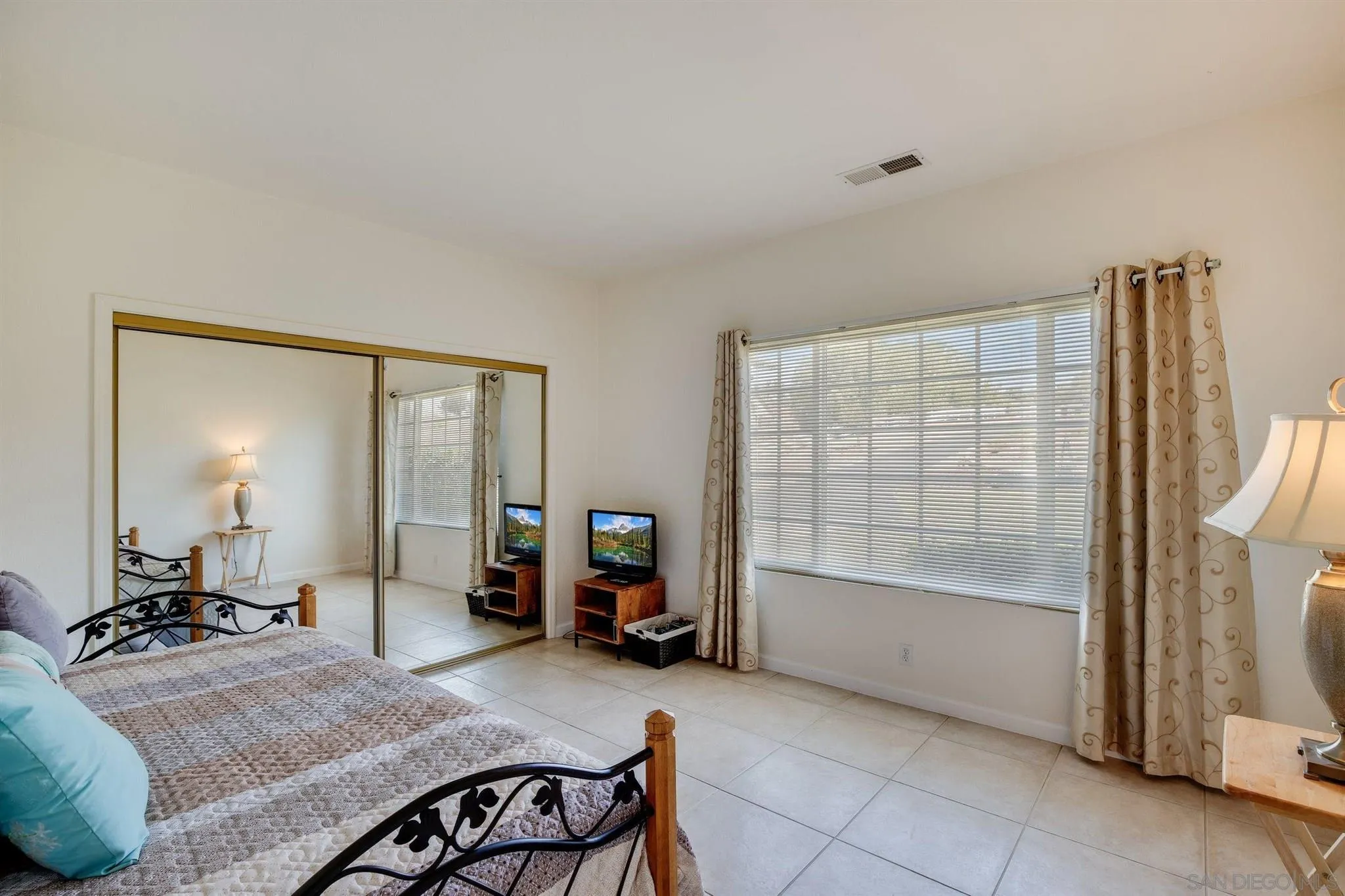 31210 Rivoli Road Valley Center, CA 92082 - Photo 24 of 62 a large bedroom with a bed and glass door