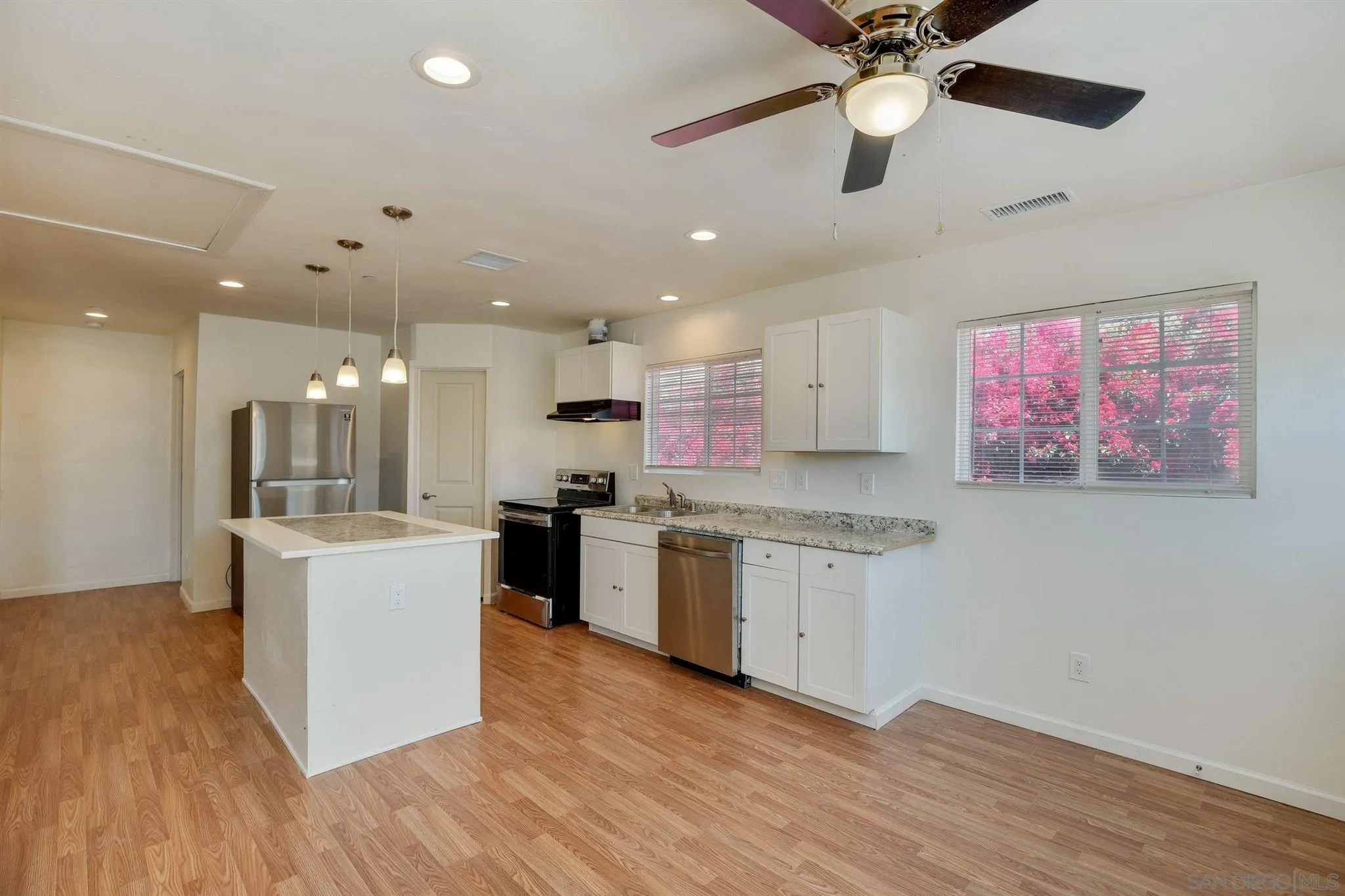 31210 Rivoli Road Valley Center, CA 92082 - Photo 47 of 62 a large kitchen with kitchen island a stove a counter top space and cabinets with wooden floor