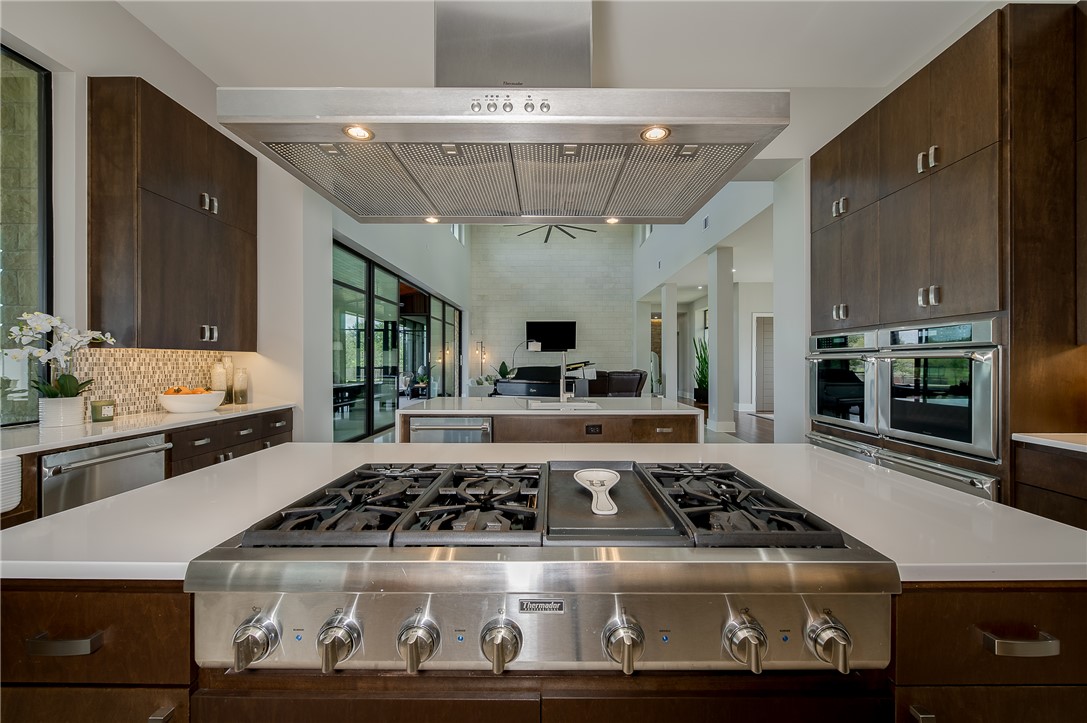 3320 Sycamore Trail Bryan, TX 77807 - Photo 14 of 48 Kitchen with light countertops, tasteful backsplash, range hood, a spacious island, and appliances with stainless steel finishes