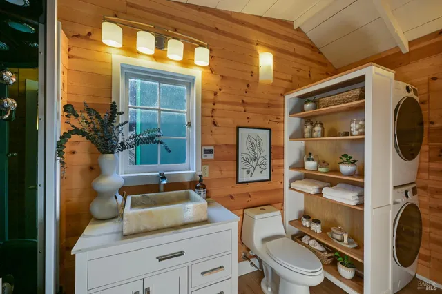 a bathroom with a granite countertop sink mirror vanity and toilet