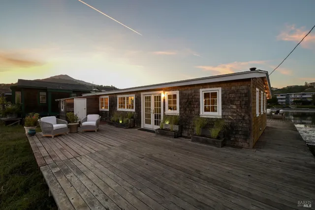 a view of a house with wooden deck and furniture