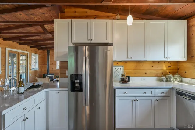 a kitchen with stainless steel appliances white cabinets and a refrigerator