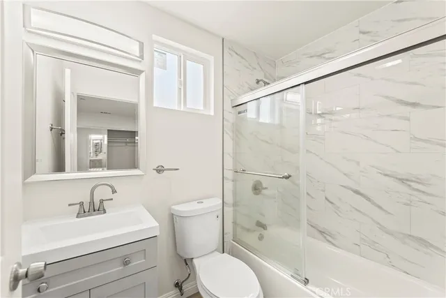 a bathroom with a sink toilet a mirror and shower