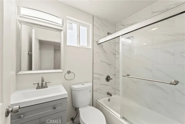 a bathroom with a toilet sink vanity tub and shower