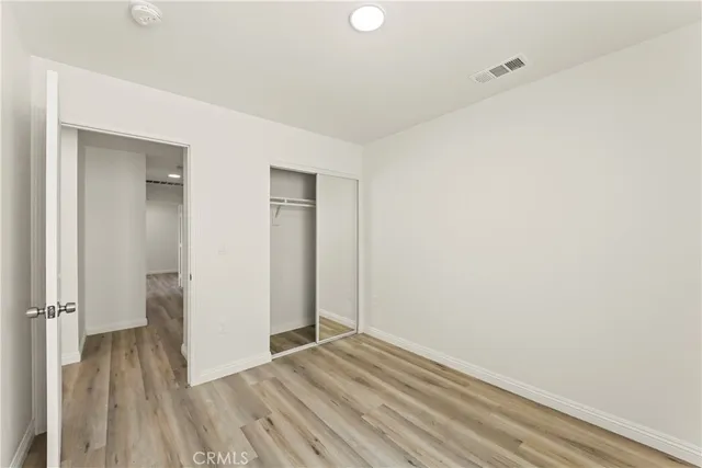 a view of a room with wooden floor and a bathroom
