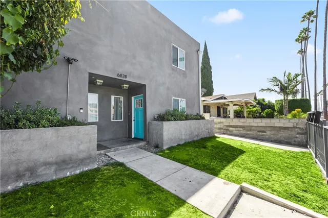 a view of an house with backyard and a tree
