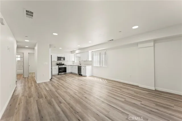 a view of an empty room with wooden floor