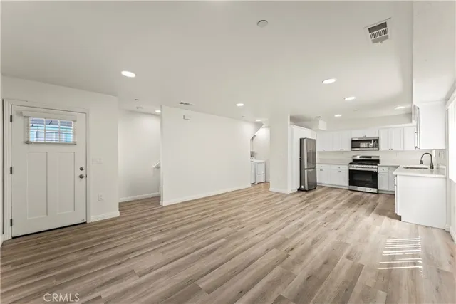 a view of kitchen with kitchen island wooden floor appliances and center island