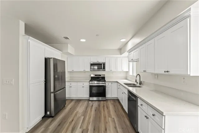 a kitchen with stainless steel appliances granite countertop a refrigerator and a stove top oven