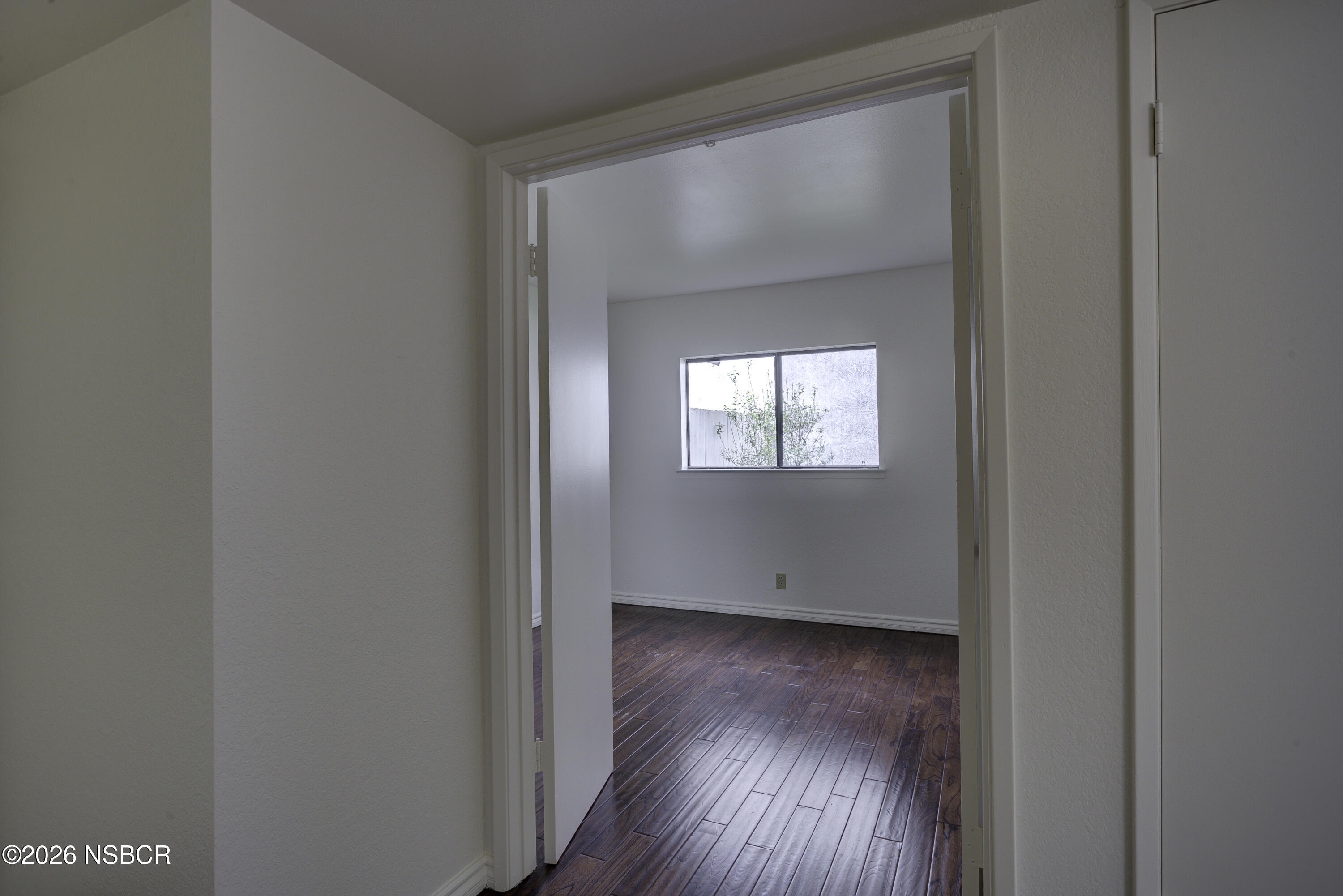 1213 Iris Court Lompoc, CA 93436 - Photo 10 of 21 a view of an empty room with wooden floor and a window