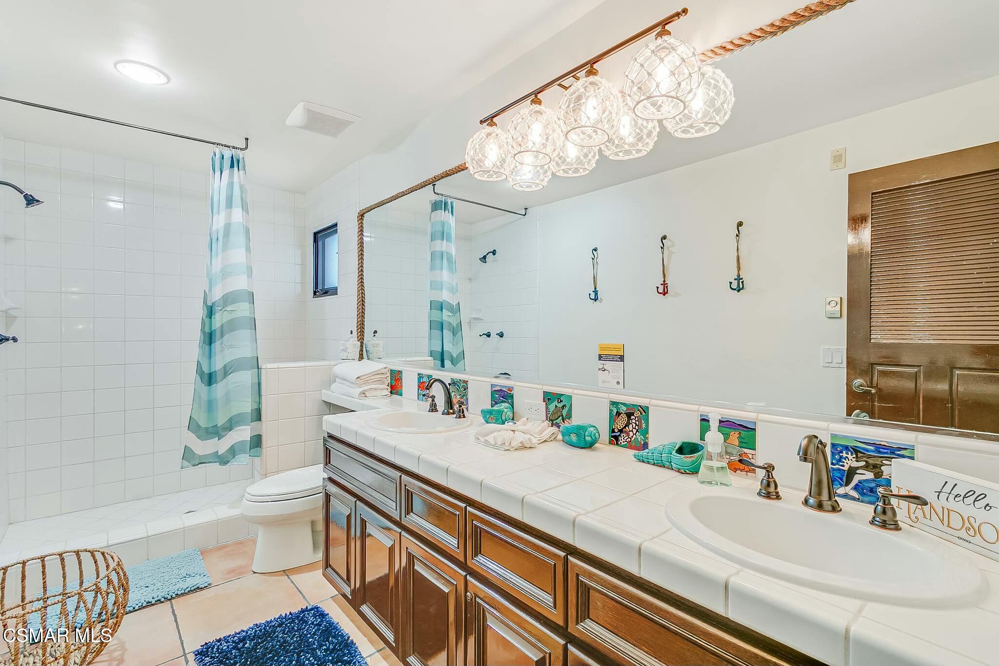 75 Gaviota Avalon, CA 90704 - Photo 32 of 49 a bathroom with a sink a large mirror and a shower