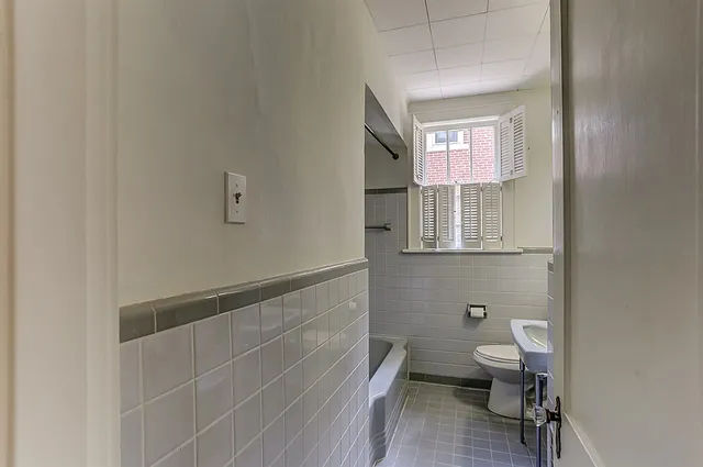 a bathroom with a toilet sink and mirror