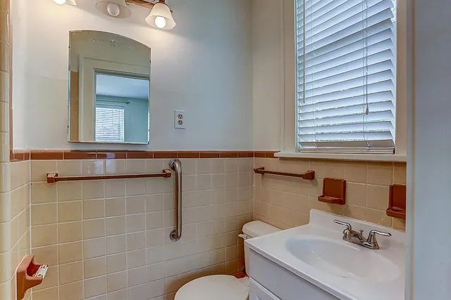 a bathroom with a sink vanity mirror and toilet