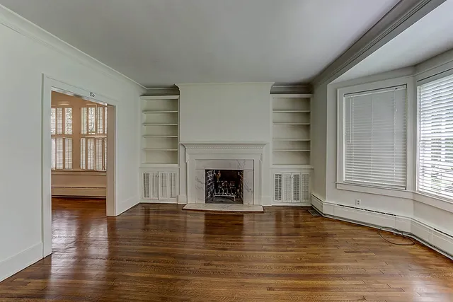 a view of a livingroom with a fireplace window and wooden floor