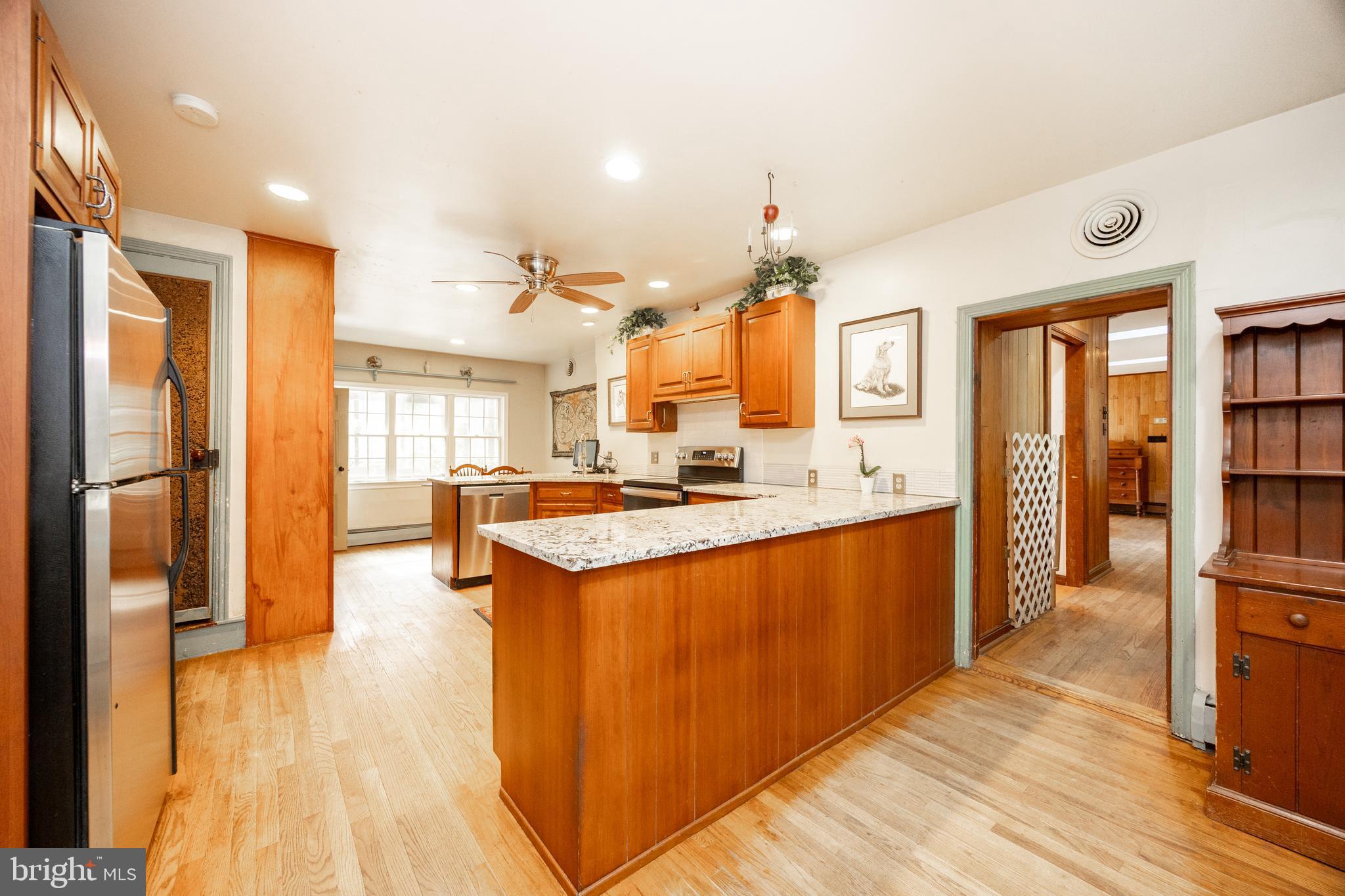 1699 Warpath Road West Chester, PA 19382 - Photo 15 of 65 a large kitchen with stainless steel appliances kitchen island granite countertop a large counter top and wooden floors