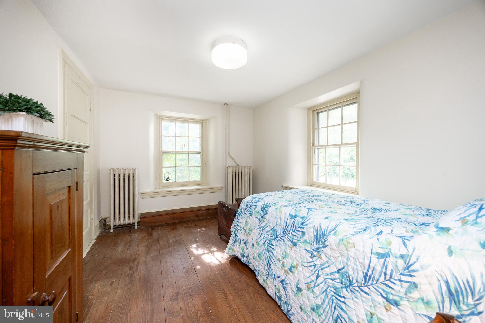 1699 Warpath Road West Chester, PA 19382 - Photo 35 of 65 a bedroom with a bed next to a window and a mirror